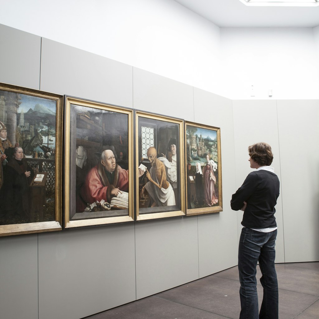 Woman viewing paintings (Hugo Van der Goes - St Hippolyte's Triptich) at Groeningemuseum.