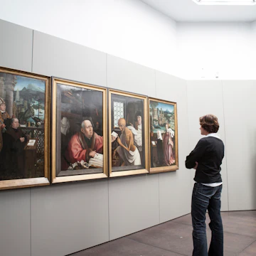 Woman viewing paintings (Hugo Van der Goes - St Hippolyte's Triptich) at Groeningemuseum.