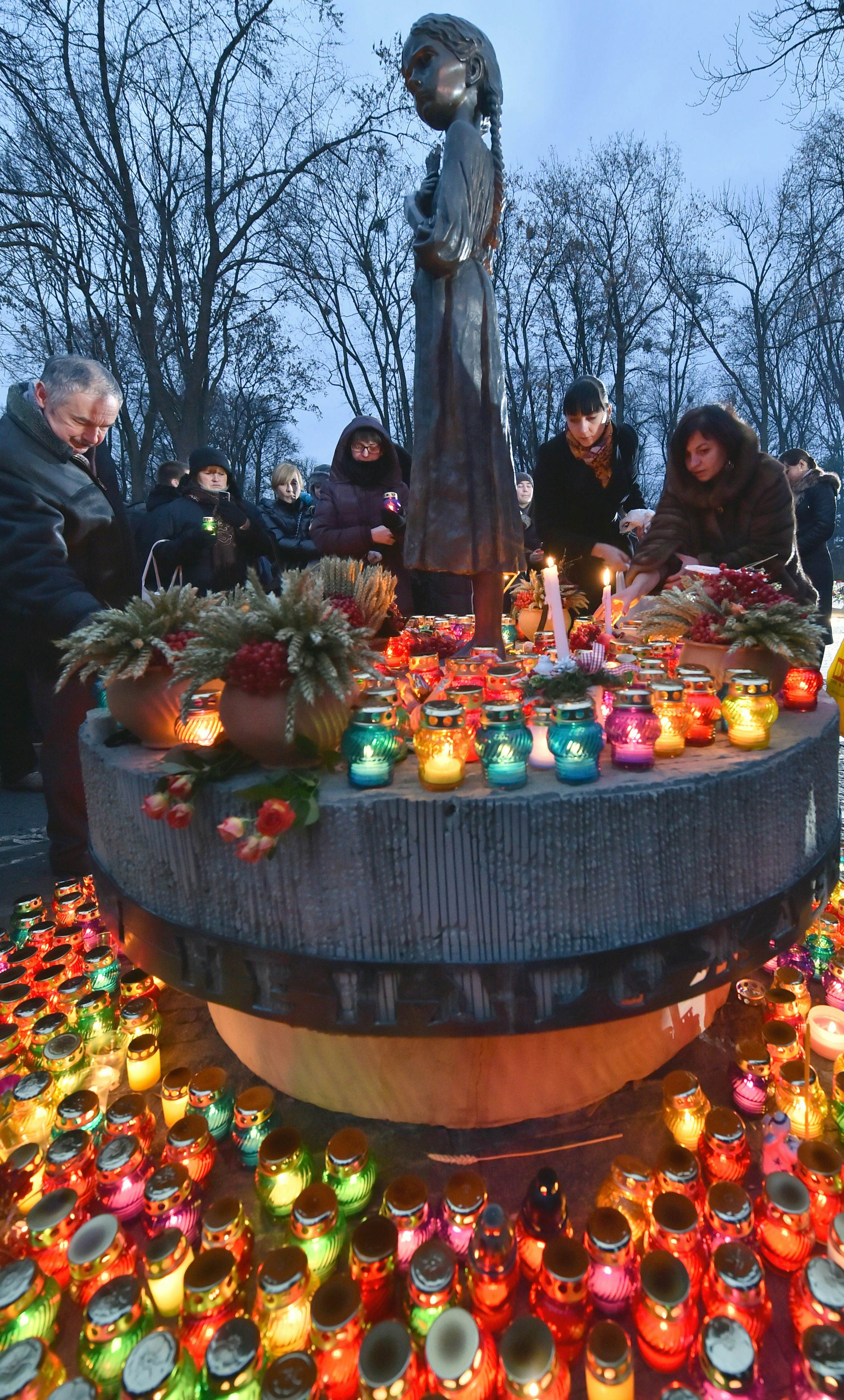 Ukrainians place candles in memory of the victims of the Holodomor famine during a ceremony at the Holodomor memorial in Kiev on November 22, 2014. Ukraine marked 81 years since the Stalin-era Holodomor famine, one of the darkest pages in its entire history that left millions dead and which is regarded by many as a genocide. The 1932-33 famine took place as harvests dwindled and Soviet leader Josef Stalin's police enforced the brutal policy of collectivising agriculture by requisitioning grain and other foodstuffs. AFP PHOTO/ SERGEI SUPINSKY        (Photo credit should read SERGEI SUPINSKY/AFP/Getty Images)