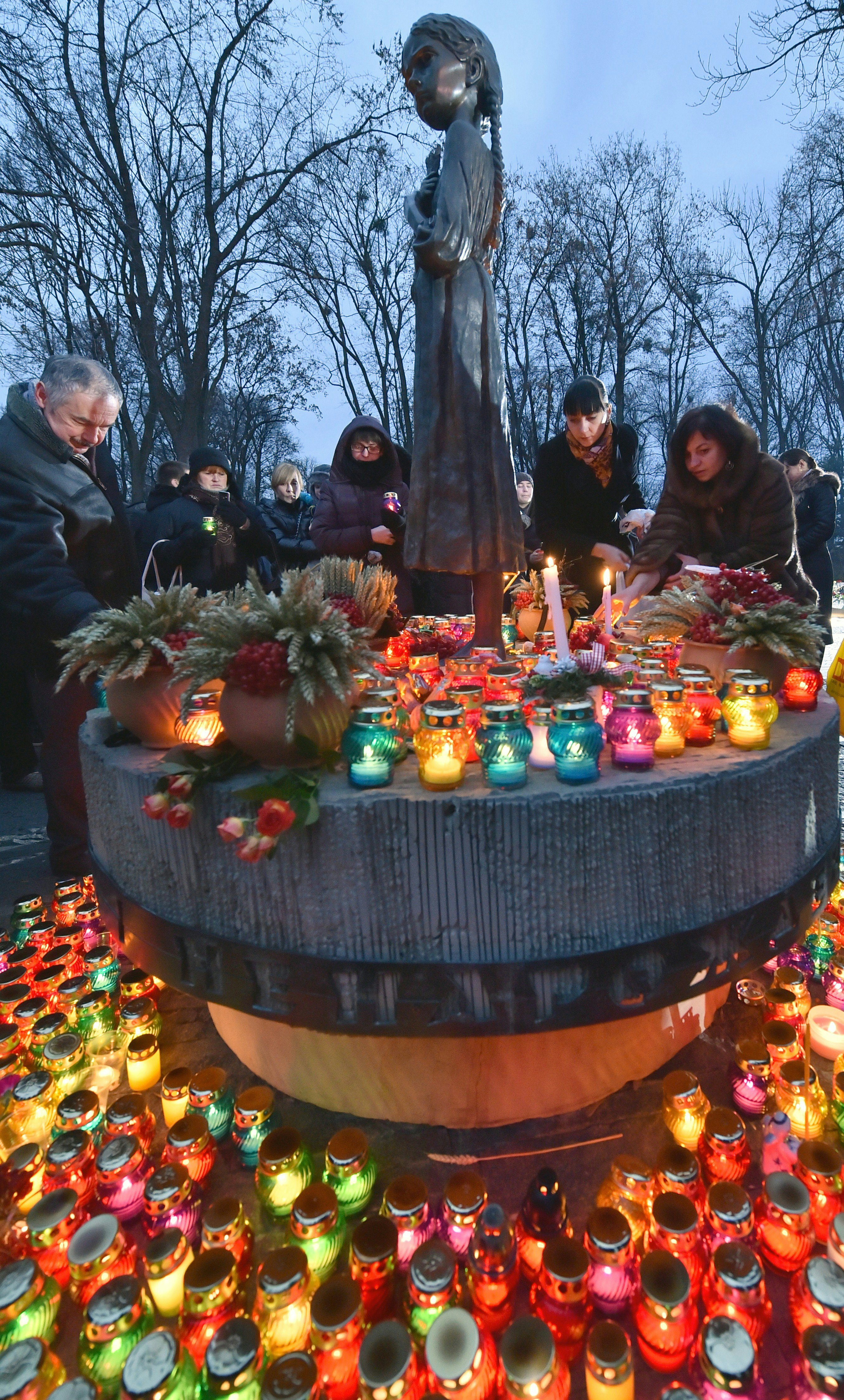 Ukrainians place candles in memory of the victims of the Holodomor famine during a ceremony at the Holodomor memorial in Kiev on November 22, 2014. Ukraine marked 81 years since the Stalin-era Holodomor famine, one of the darkest pages in its entire history that left millions dead and which is regarded by many as a genocide. The 1932-33 famine took place as harvests dwindled and Soviet leader Josef Stalin's police enforced the brutal policy of collectivising agriculture by requisitioning grain and other foodstuffs. AFP PHOTO/ SERGEI SUPINSKY        (Photo credit should read SERGEI SUPINSKY/AFP/Getty Images)