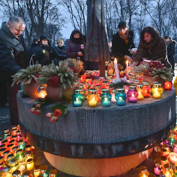 Ukrainians place candles in memory of the victims of the Holodomor famine during a ceremony at the Holodomor memorial in Kiev on November 22, 2014. Ukraine marked 81 years since the Stalin-era Holodomor famine, one of the darkest pages in its entire history that left millions dead and which is regarded by many as a genocide. The 1932-33 famine took place as harvests dwindled and Soviet leader Josef Stalin's police enforced the brutal policy of collectivising agriculture by requisitioning grain and other foodstuffs. AFP PHOTO/ SERGEI SUPINSKY (Photo credit should read SERGEI SUPINSKY/AFP/Getty Images)