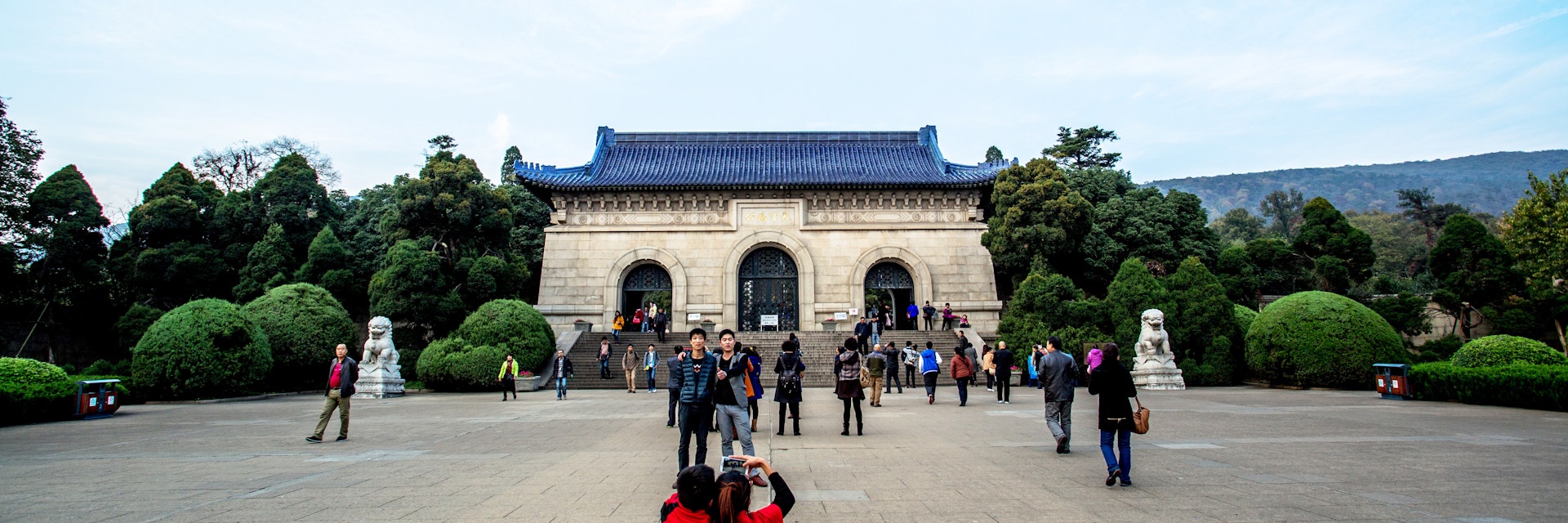 NANJING, CHINA - 2014/11/12: Tourists take photos in front of Dr. Sun Yat-sen's Mausoleum. Sun's Mausoleum situated at the foot of Mount Zijin in Nanjing,  Sun is considered to be the "Father of Modern China" both in mainland China and Taiwan, as well as the founder of Republic of China.  As the Holy land of Chinese people both home and abroad, Dr. Sun Yat-sen's Mausoleum attracts a lot of visitors every year. (Photo by Zhang Peng/LightRocket via Getty Images)