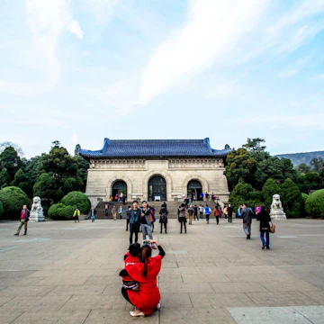 NANJING, CHINA - 2014/11/12: Tourists take photos in front of Dr. Sun Yat-sen's Mausoleum. Sun's Mausoleum situated at the foot of Mount Zijin in Nanjing, Sun is considered to be the "Father of Modern China" both in mainland China and Taiwan, as well as the founder of Republic of China. As the Holy land of Chinese people both home and abroad, Dr. Sun Yat-sen's Mausoleum attracts a lot of visitors every year. (Photo by Zhang Peng/LightRocket via Getty Images)