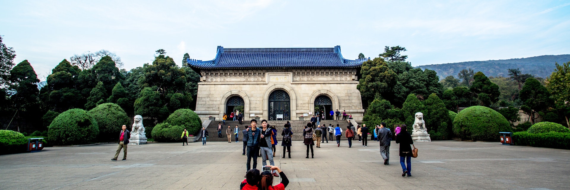 NANJING, CHINA - 2014/11/12: Tourists take photos in front of Dr. Sun Yat-sen's Mausoleum. Sun's Mausoleum situated at the foot of Mount Zijin in Nanjing, Sun is considered to be the "Father of Modern China" both in mainland China and Taiwan, as well as the founder of Republic of China. As the Holy land of Chinese people both home and abroad, Dr. Sun Yat-sen's Mausoleum attracts a lot of visitors every year. (Photo by Zhang Peng/LightRocket via Getty Images)