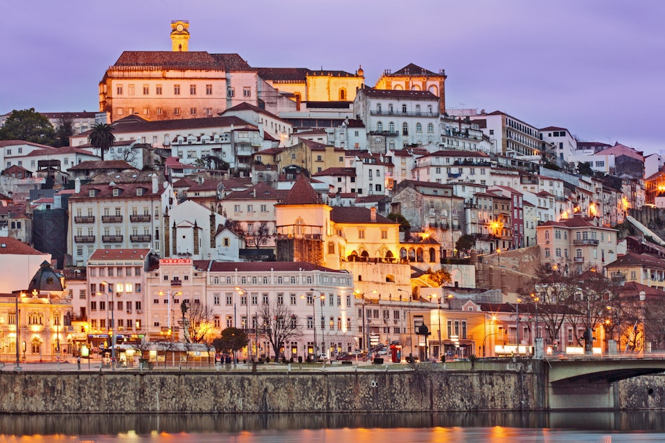 Portugal, Centro, Baixo Mondego, Coimbra, Twilight view of medieval city centre, UNESCO World Heritage listed University of Coimbra-Alta and Sofia (crowning hill), and Mondego river