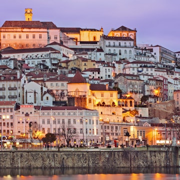 Portugal, Centro, Baixo Mondego, Coimbra, Twilight view of medieval city centre, UNESCO World Heritage listed University of Coimbra-Alta and Sofia (crowning hill), and Mondego river