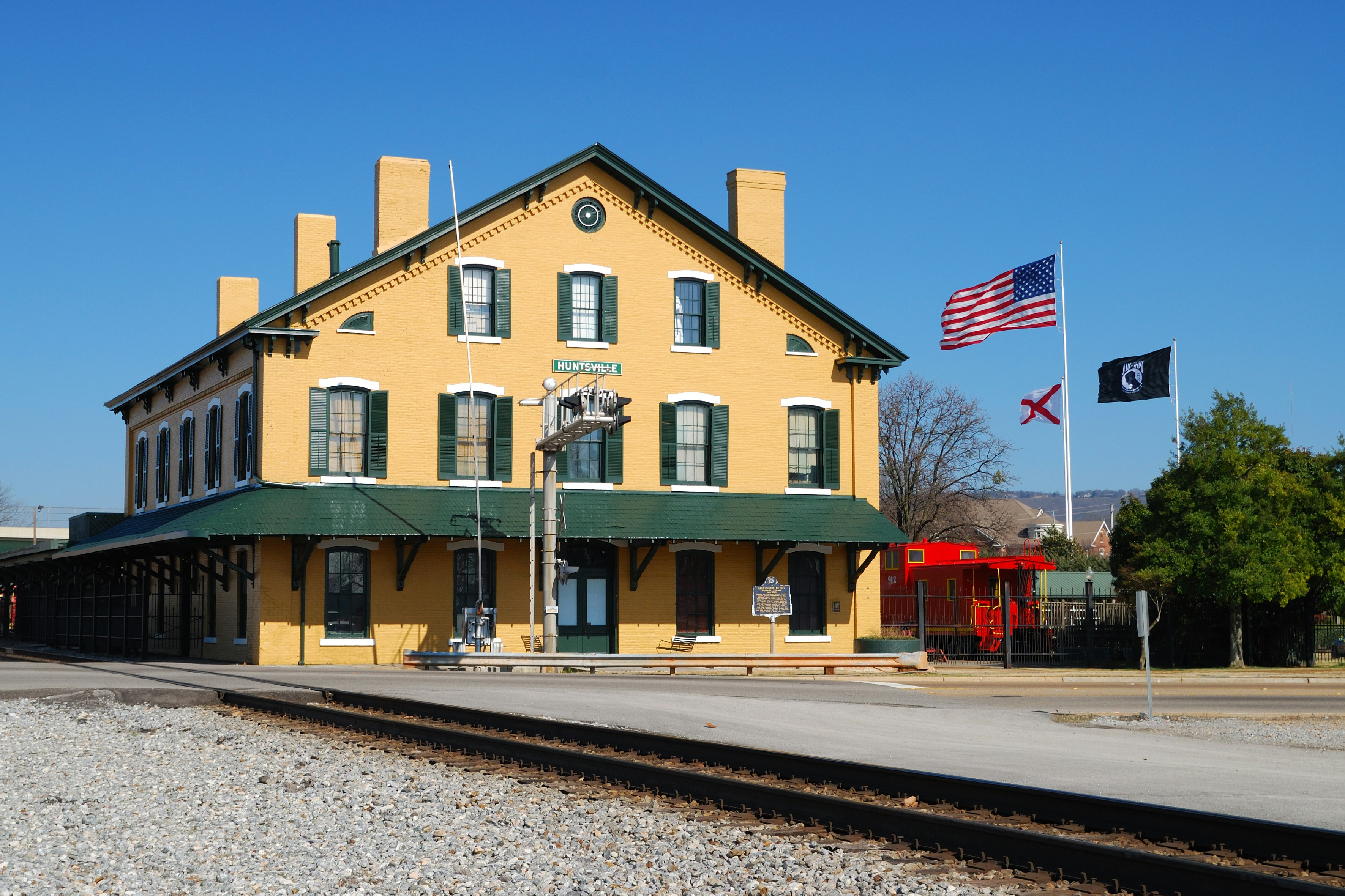Flags from the veterans memorial fly behind the train depot in Huntsville Alabama.