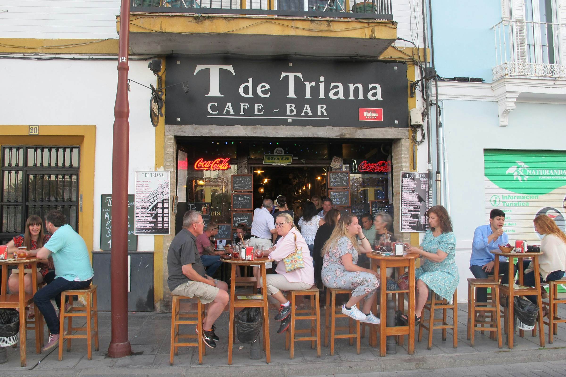 T de Triana cafe bar with people sitting on chairs outside.