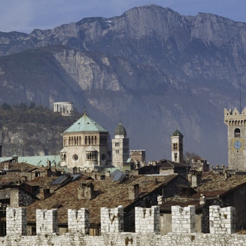 City walls in Piazza della Fiera, in the foreground, with the towers of Trento Cathedral and the Mausoleum of Cesare Battisti in the background, Trento, Trentino-Alto Adige, Italy