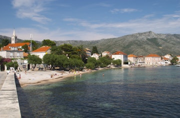Tourists with the village and Mount Sveti Ilija mountain. Orebic town, holiday resort on the south coast of the Peljesac peninsula. Dalmatian Coast, Croatia