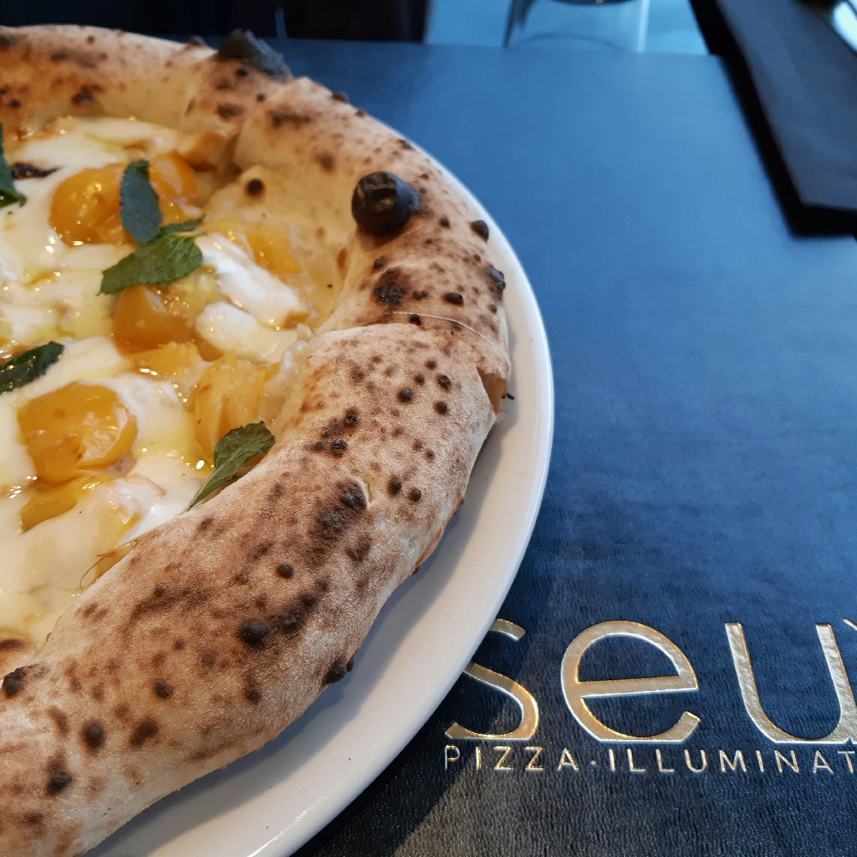 Smoked mozzarella, yellow tomatoes, and mint pizza at Seu Pizza Illuminati.