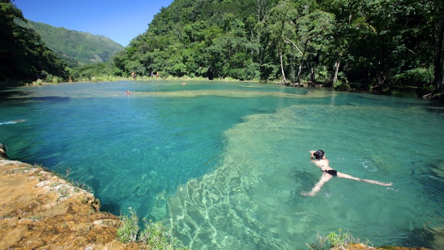 Visitors swimming in turquoise-coloured waters of Semuc Champey.