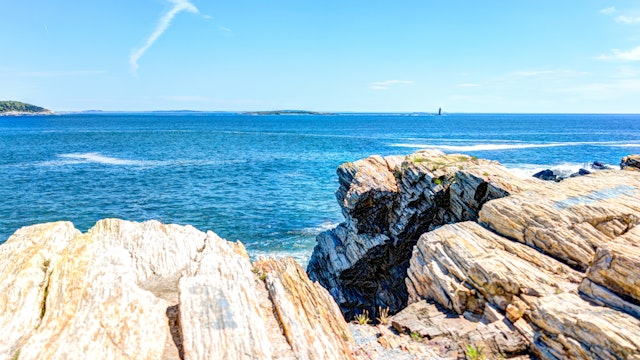 Cliff rocks by trail by Portland Head Lighthouse in Fort Williams park in Cape, Elizabeth Maine during summer day