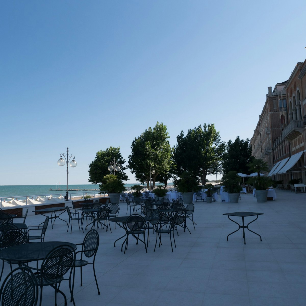 The elegant terrace overlooks the Hotel Excelsior beach