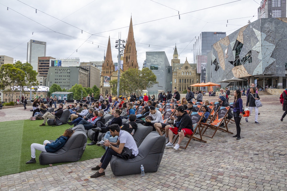 Australia, Melbourne - September 2018 - People sitting on beanbags and chairs in front of main stage at Federation Square