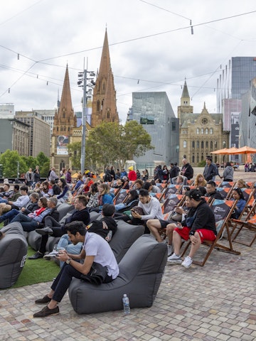 Australia, Melbourne - September 2018 - People sitting on beanbags and chairs in front of main stage at Federation Square