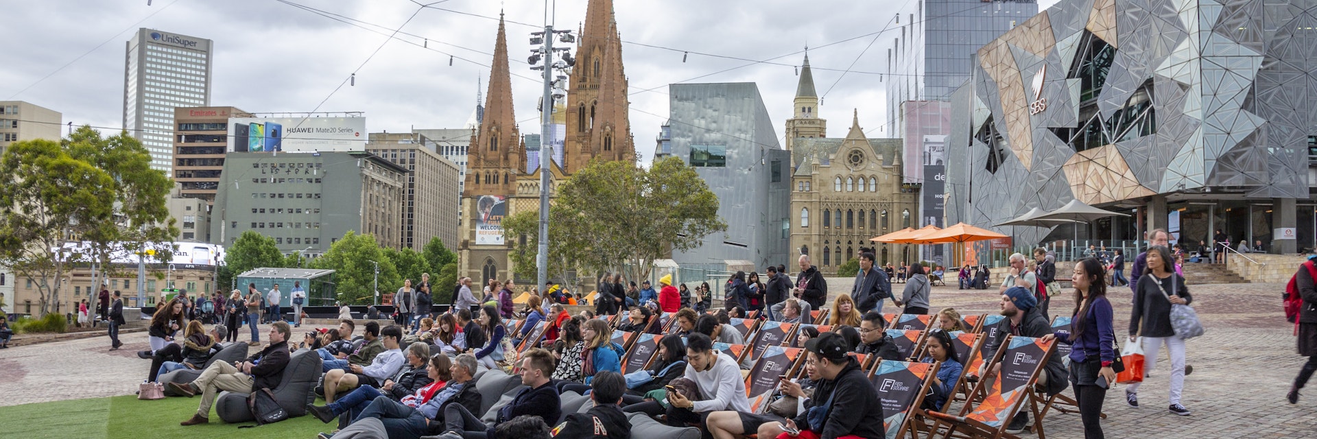 Australia, Melbourne - September 2018 - People sitting on beanbags and chairs in front of main stage at Federation Square