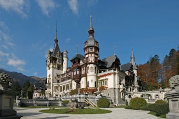 Romania, Castelul Peles (Peles Castle), facade seen from gardens set against blue sky
