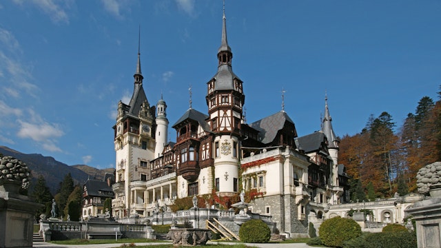 Romania, Castelul Peles (Peles Castle), facade seen from gardens set against blue sky