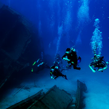 Scuba divers explore the El Aguila shipwreck in Roatan, Honduras. The ship sank in 110 feet of water in 1997.