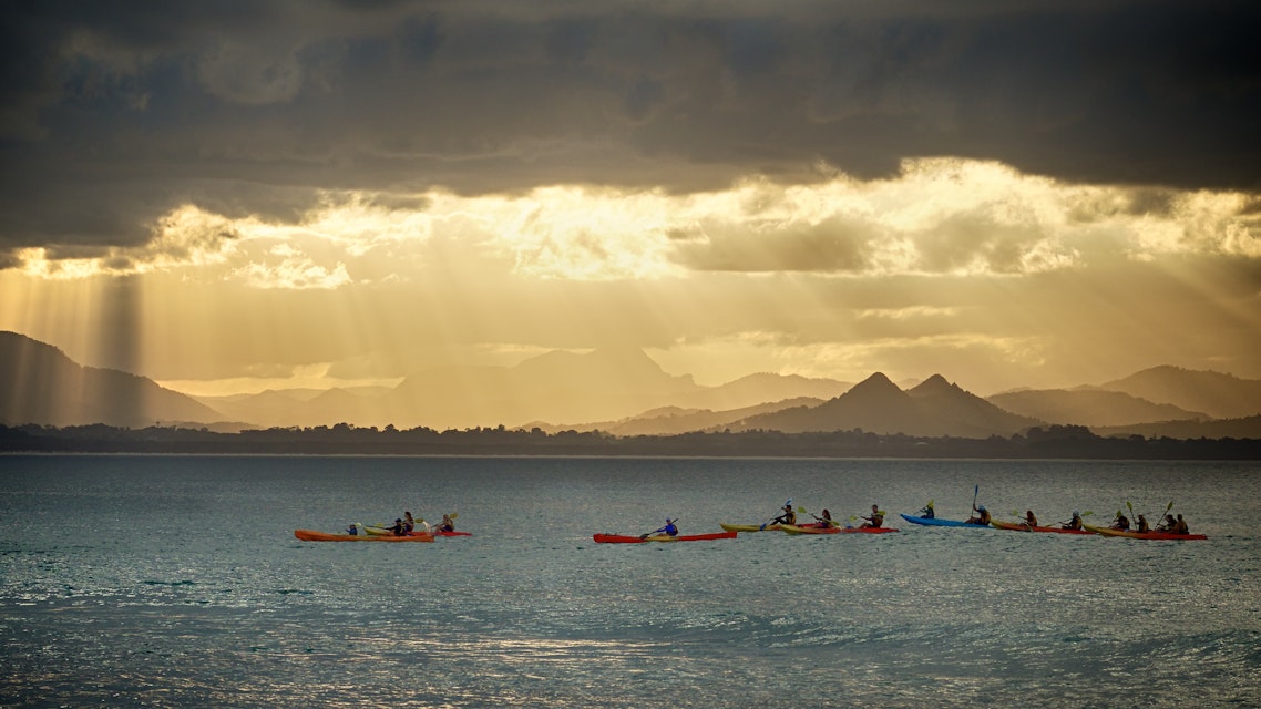 Kayakers watch for whales as the sun sets