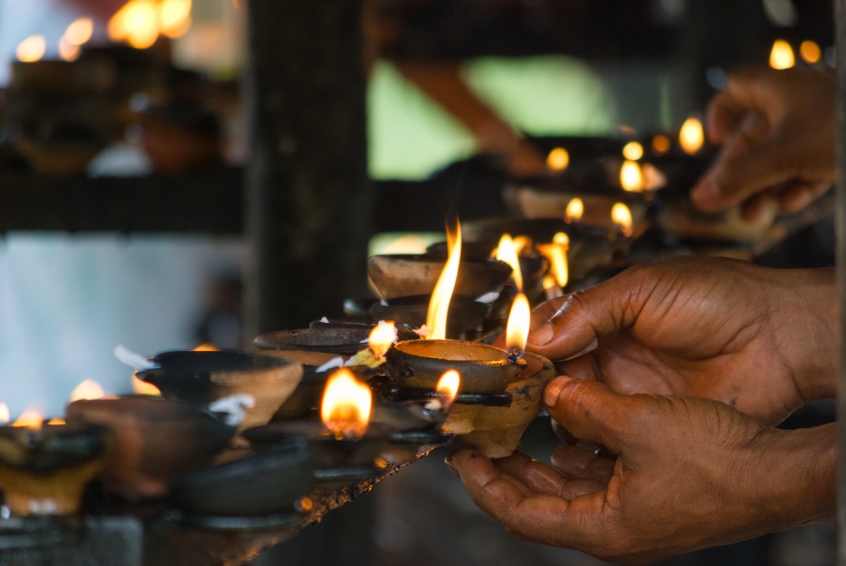 Hands Lighting Buddhist Oil Lamps; Shutterstock ID 143182351; Your name (First / Last): Josh Vogel; GL account no.: 56530; Netsuite department name: Online Design; Full Product or Project name including edition: Digital Content/Sights