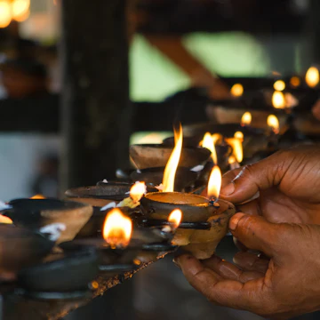 Hands Lighting Buddhist Oil Lamps; Shutterstock ID 143182351; Your name (First / Last): Josh Vogel; GL account no.: 56530; Netsuite department name: Online Design; Full Product or Project name including edition: Digital Content/Sights