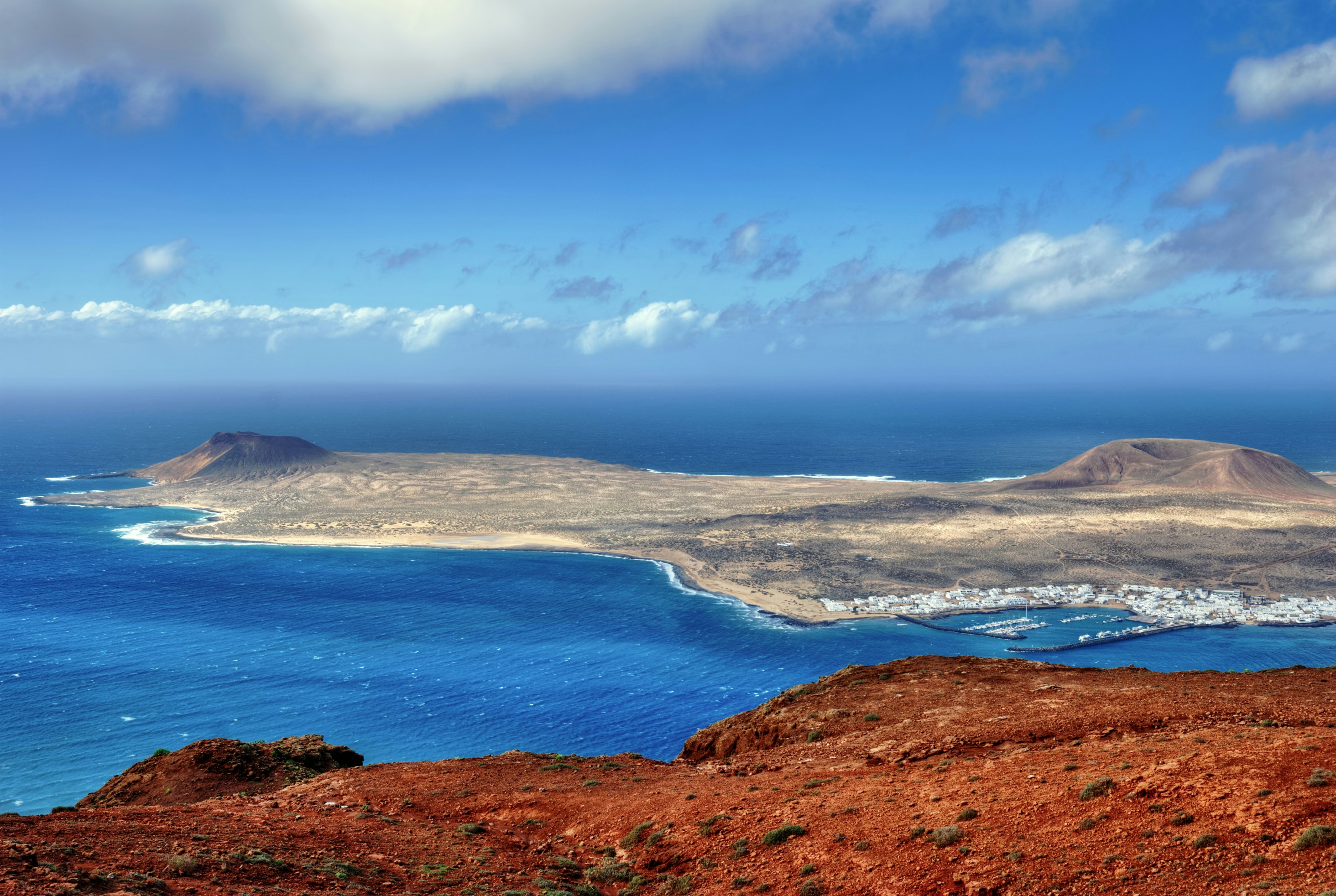 The Island of La Graciosa and the port of Caleta del Sebo taken from the Mirador del Rio, a famous viewpoint on Lanzarote, in the Spanish Canary Islands.; Shutterstock ID 74001898; Your name (First / Last): Tom Stainer; GL account no.: 65050 ; Netsuite department name: Online Editorial; Full Product or Project name including edition: Best in Travel 2018