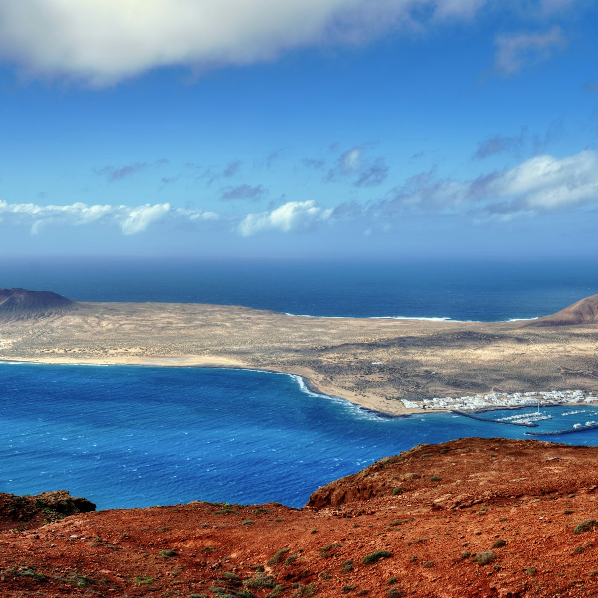 The Island of La Graciosa and the port of Caleta del Sebo taken from the Mirador del Rio, a famous viewpoint on Lanzarote, in the Spanish Canary Islands.; Shutterstock ID 74001898; Your name (First / Last): Tom Stainer; GL account no.: 65050 ; Netsuite department name: Online Editorial; Full Product or Project name including edition: Best in Travel 2018