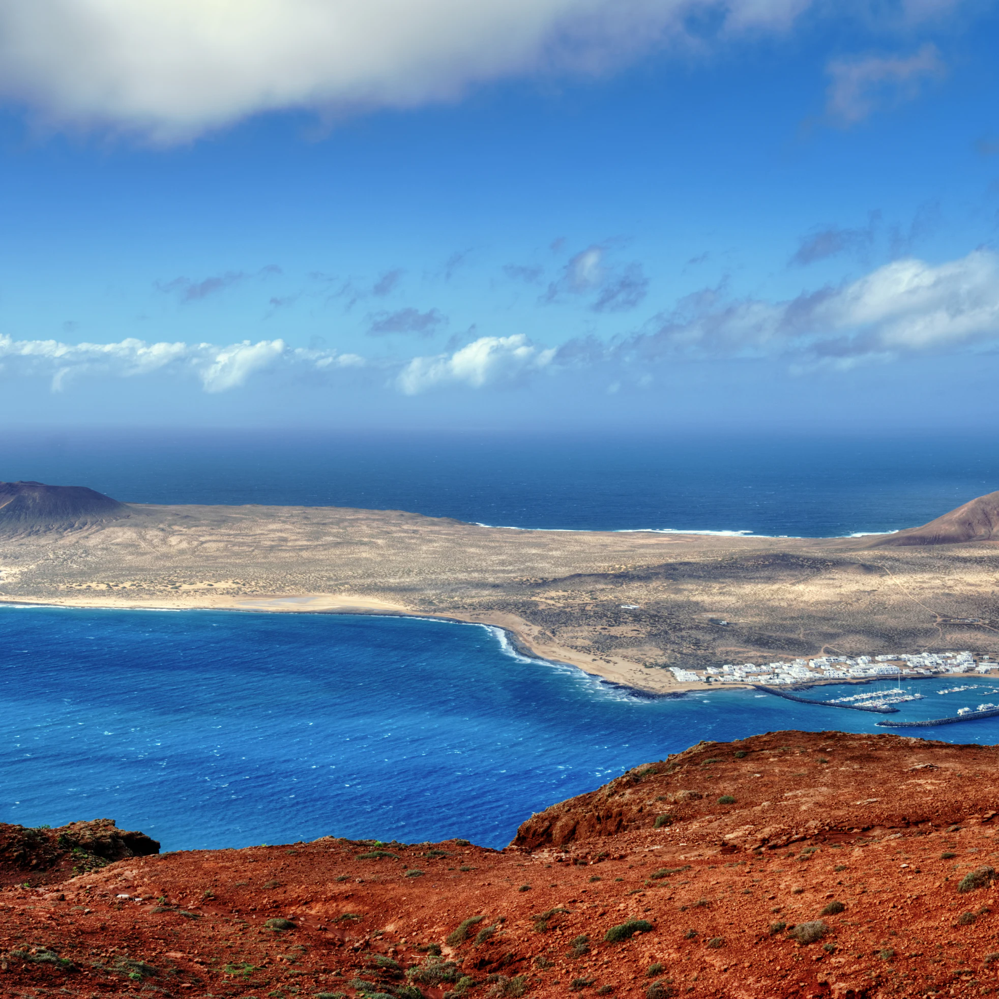The Island of La Graciosa and the port of Caleta del Sebo taken from the Mirador del Rio, a famous viewpoint on Lanzarote, in the Spanish Canary Islands.; Shutterstock ID 74001898; Your name (First / Last): Tom Stainer; GL account no.: 65050 ; Netsuite department name: Online Editorial; Full Product or Project name including edition: Best in Travel 2018