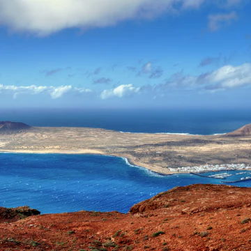 The Island of La Graciosa and the port of Caleta del Sebo taken from the Mirador del Rio, a famous viewpoint on Lanzarote, in the Spanish Canary Islands.; Shutterstock ID 74001898; Your name (First / Last): Tom Stainer; GL account no.: 65050 ; Netsuite department name: Online Editorial; Full Product or Project name including edition: Best in Travel 2018