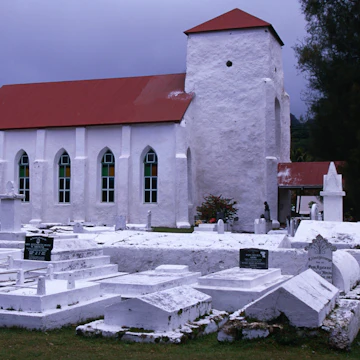 One of many white Christian churches and graveyards on the island of Rarotonga.