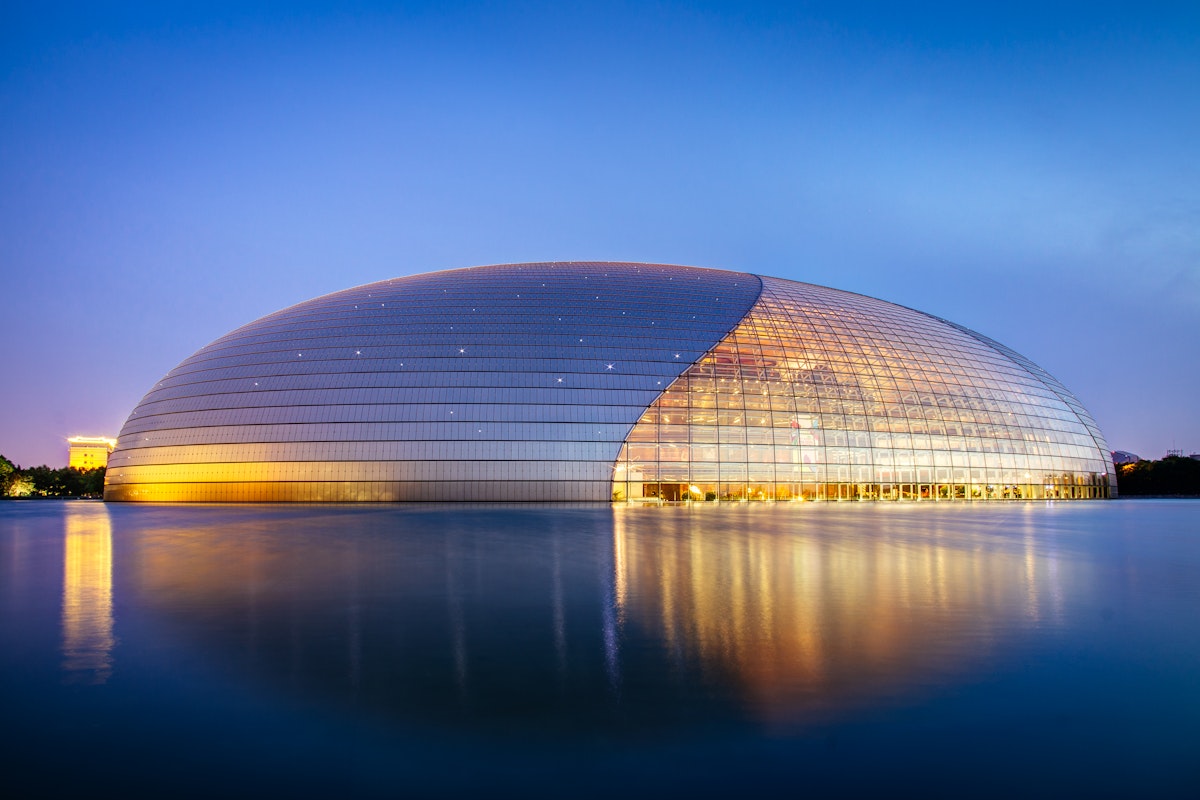 The National Centre for the Performing Arts (NCPA), literally as National Grand Theatre, and colloquially described as The Giant Egg, is an opera house in Beijing. The Centre, an ellipsoid dome of titanium and glass surrounded by an artificial lake, seats 5,452 people in three halls and is almost 12,000 mￂﾲ in size. It was designed by French architect Paul Andreu. Construction started in December 2001 and the inaugural concert was held in December 2007.