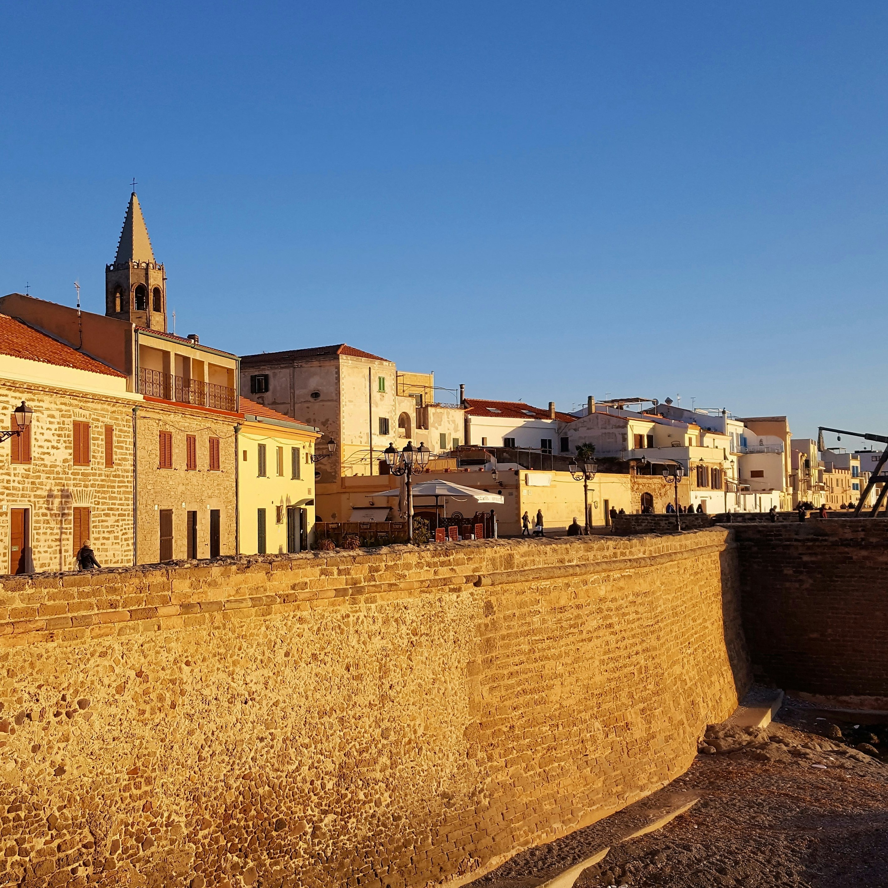 Sea wall of Alghero. North of Sardinia. Itlay.Alghero's golden sea walls, built around the centro storico by the Aragonese in the 16th century, are a highlight of the town's historic cityscape.; Shutterstock ID 576280477; Your name (First / Last): Anna Tyler; GL account no.: 65050; Netsuite department name: Online Editorial; Full Product or Project name including edition: destination-image-southern-europe
