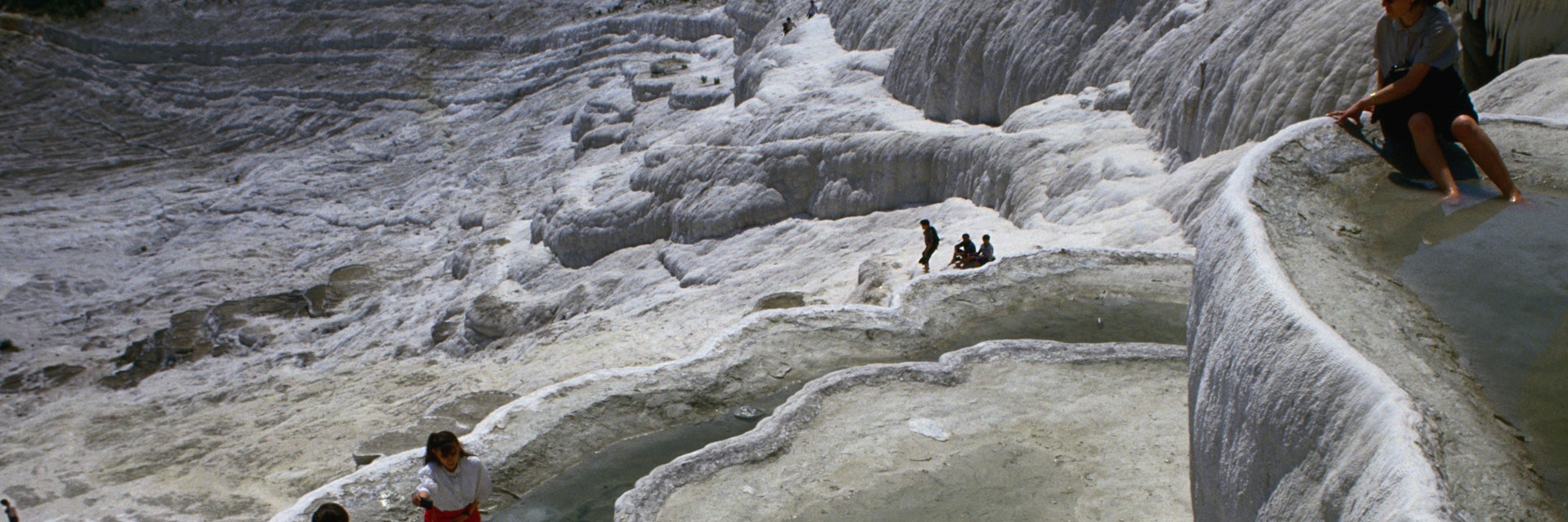 Calcium laden mineral waters cascade over the cliffs of Pamukkale, and as it cools the calcium, it precipitates and clings to the cliffs forming the snow like waterfalls of white stone, however, due to circumstances the site has deteriorated substantially over the years