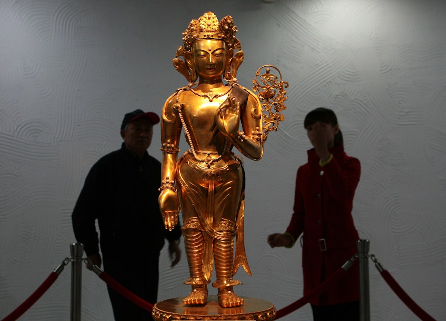 NANJING, CHINA - NOVEMBER 19: (CHINA OUT) Visitors view the "Gold Guan Yin Bodhisattva Statue", made during the Warring States period (475 to 221 BC) at the Valuable Treasures Special Exhibition In Nanjing Museum on November 19, 2007 in Nanjing of Jiangsu Province, China. Eighteen priceless treasures were selected from the museum's 420,000 collections, dating back 5,000 years ago. (Photo by China Photos/Getty Images)