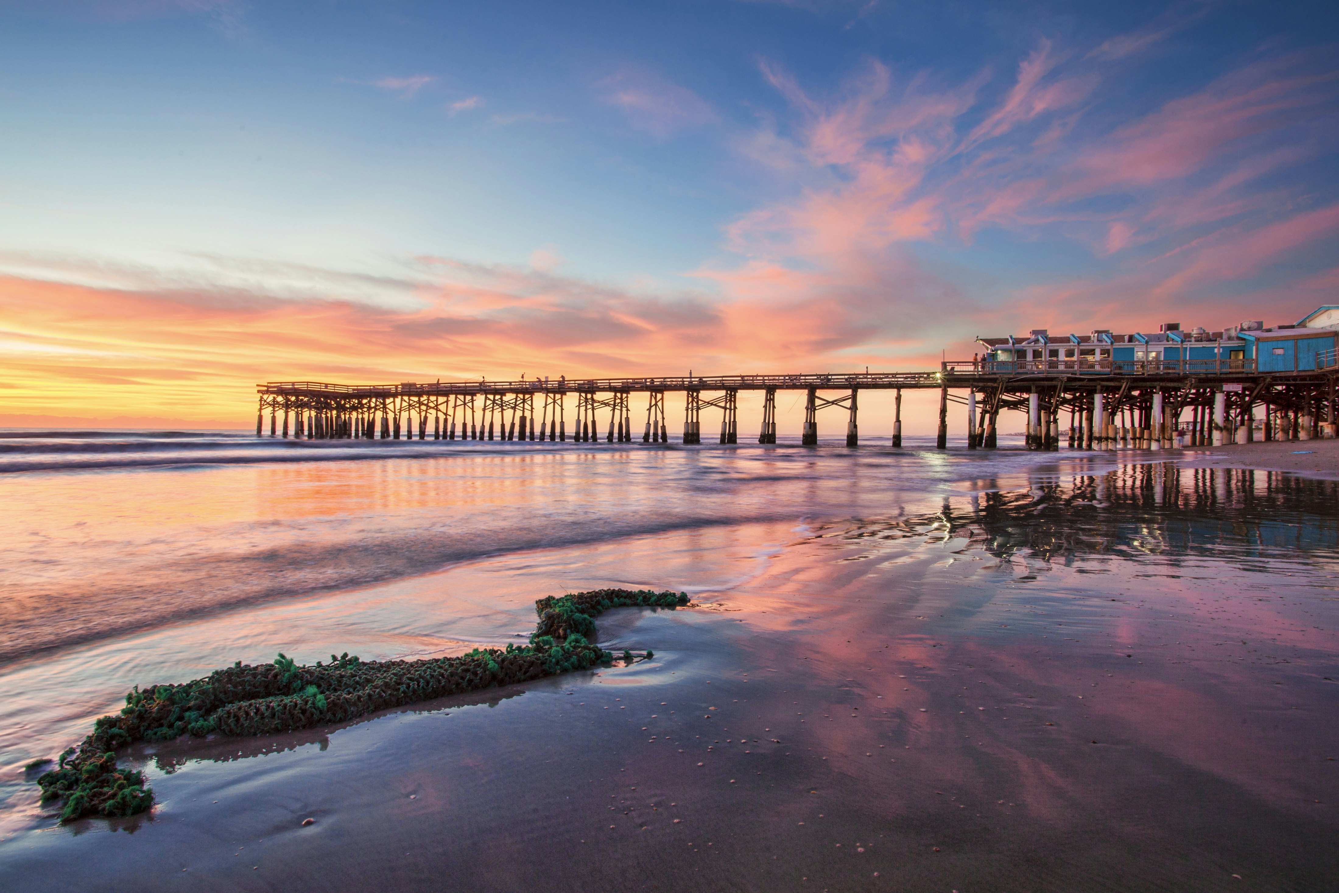 Old fish net washed ashore on Cocoa Beach Florida with the Cocoa Pier in the background with a beautiful sunrise
