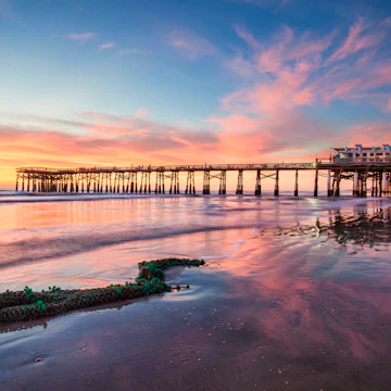 Old fish net washed ashore on Cocoa Beach Florida with the Cocoa Pier in the background with a beautiful sunrise