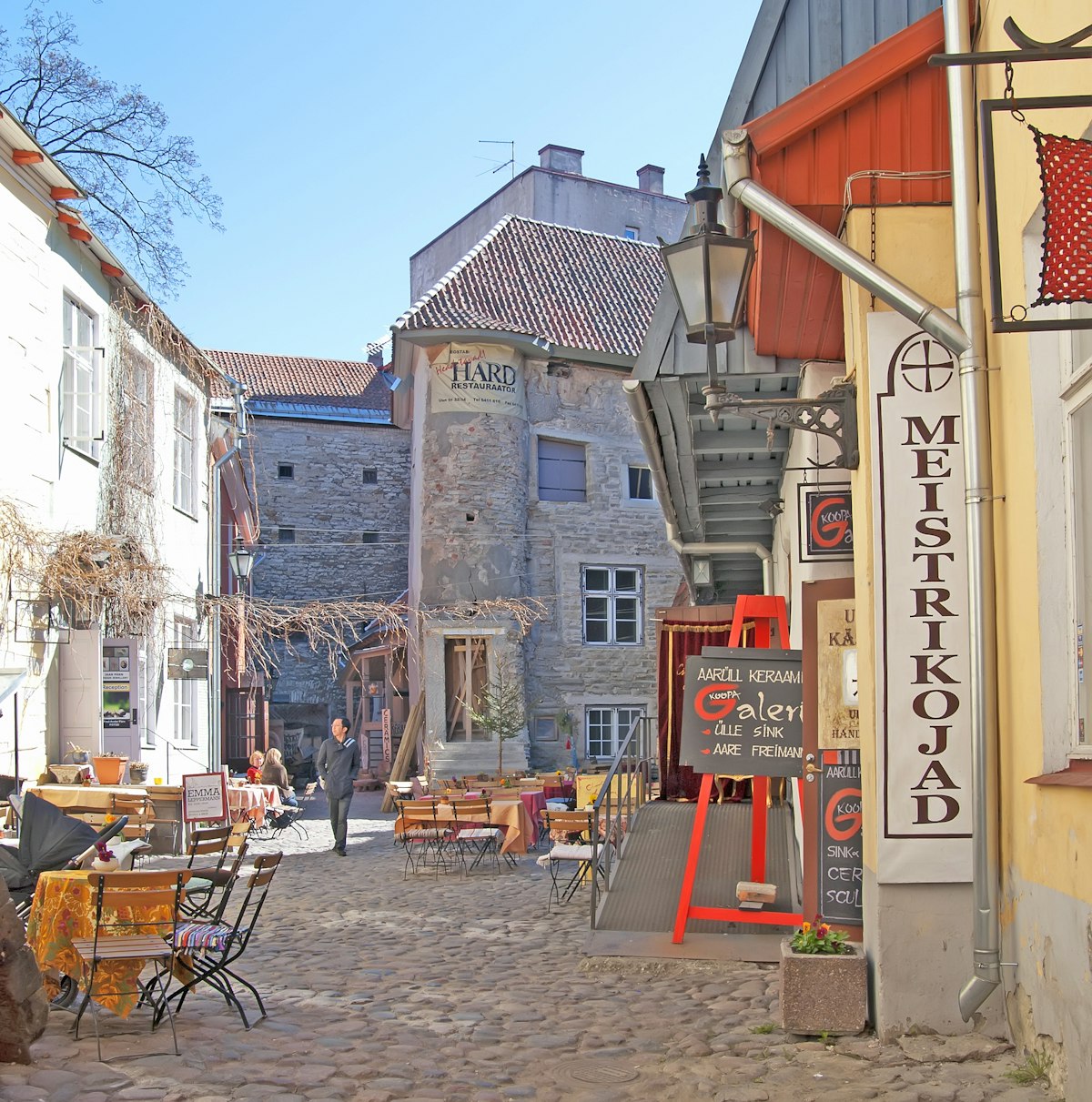TALLINN, ESTONIA - MAY 1, 2011: Courtyard with cafes and souvenir shops in Old Town. Old Town is historical center of the city and a  part of the UNESCO World Heritage site; Shutterstock ID 246197989; Your name (First / Last): Lauren Gillmore; GL account no.: 56530; Netsuite department name: Online-Design; Full Product or Project name including edition: 65050/ Online Design /LaurenGillmore/POI