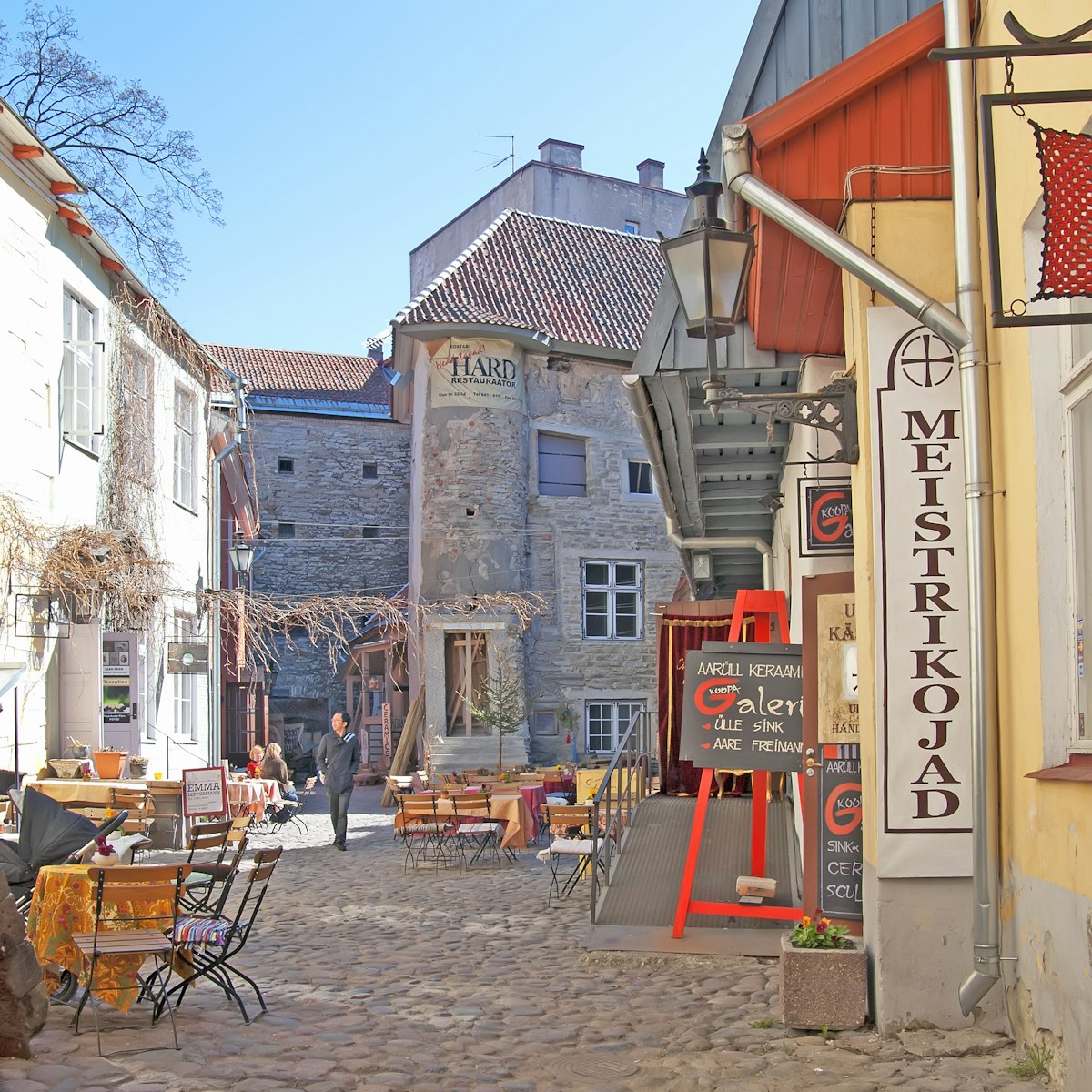 TALLINN, ESTONIA - MAY 1, 2011: Courtyard with cafes and souvenir shops in Old Town. Old Town is historical center of the city and a  part of the UNESCO World Heritage site; Shutterstock ID 246197989; Your name (First / Last): Lauren Gillmore; GL account no.: 56530; Netsuite department name: Online-Design; Full Product or Project name including edition: 65050/ Online Design /LaurenGillmore/POI