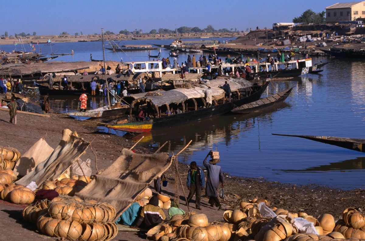 Fully laden Pinasses docked at the jetty with more cargo on the shores of the Niger river, Mopti