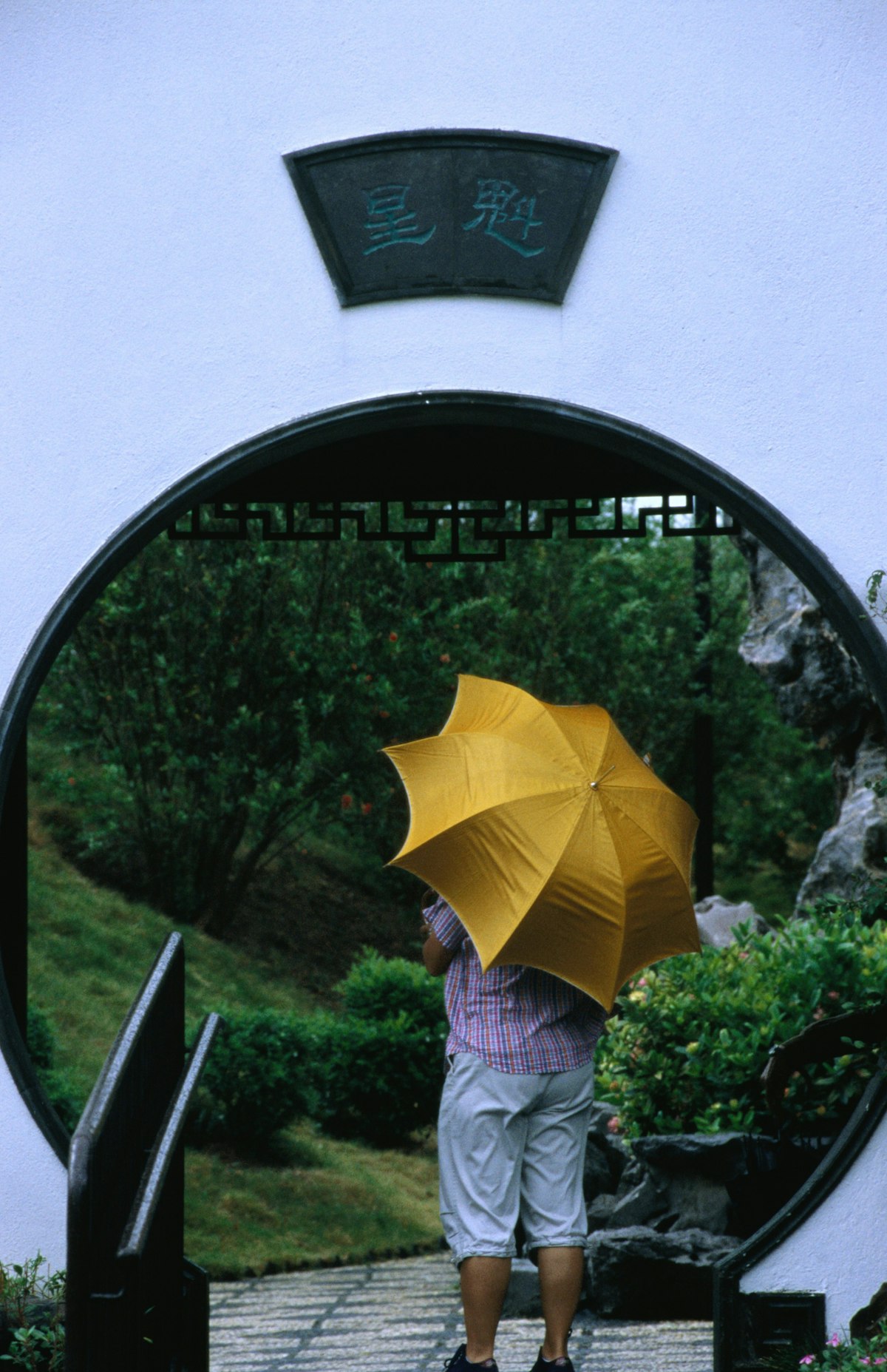 A visitor to the Kowloon walled city park walks through the Moon Gate.