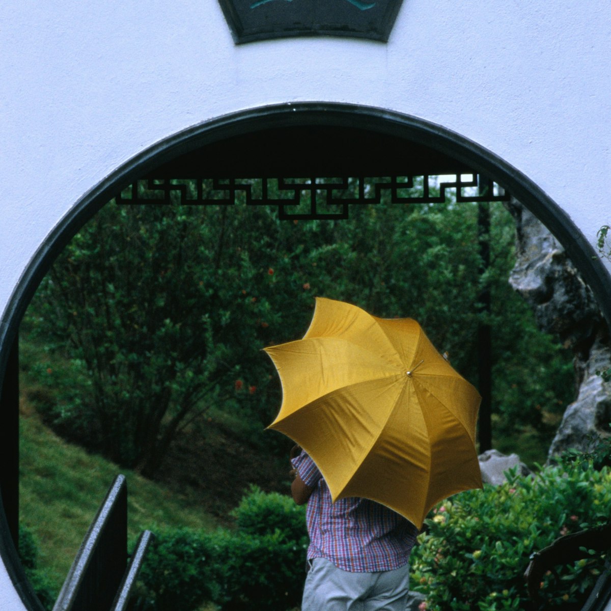 A visitor to the Kowloon walled city park walks through the Moon Gate.