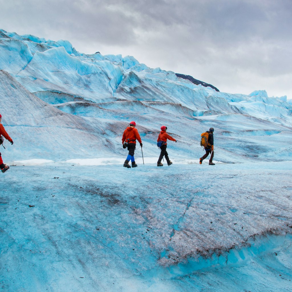 Four people walking on Mendenhall Glacier, Alaska, USA