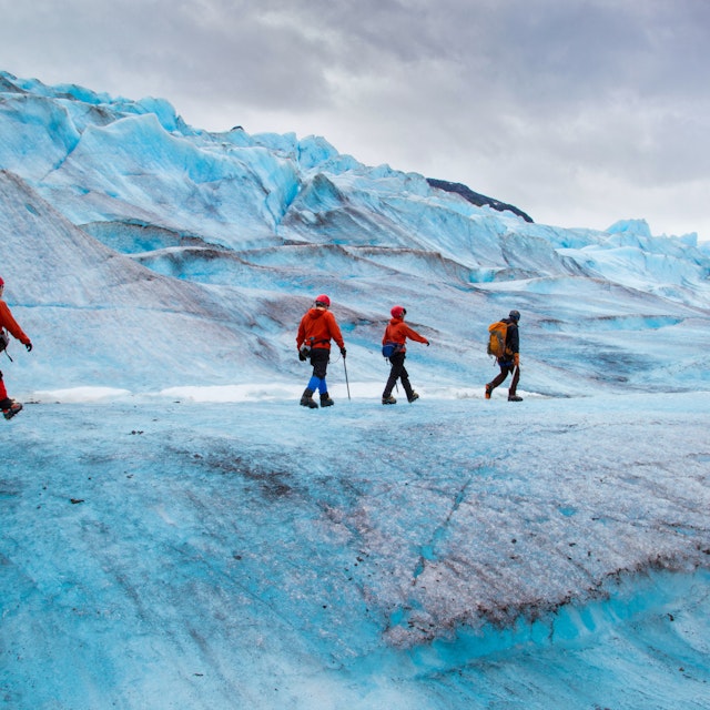 Four people walking on Mendenhall Glacier, Alaska, USA