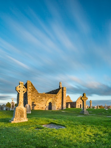 The monastery of Clonmacnoise is lighting golden in the evening sun.