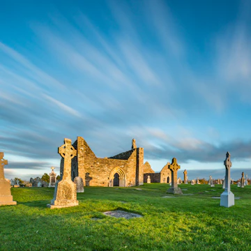 The monastery of Clonmacnoise is lighting golden in the evening sun.