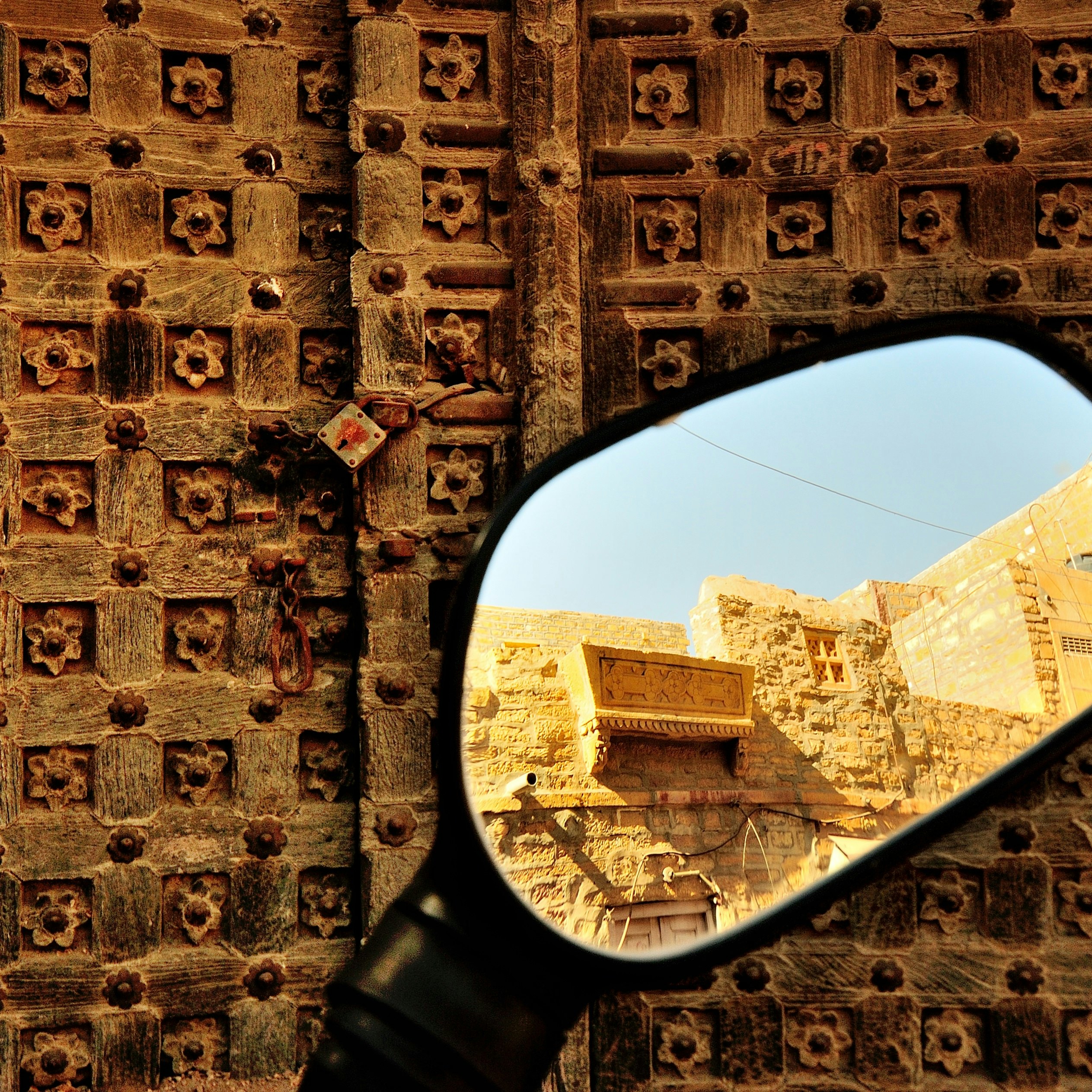500px Photo ID: 71843661 - Jaisalmer is a unique place, with the majority of the population of the dusty desert town still residing inside the centuries old fort. Making it the Living Fort. Cars, bikes can be driven inside the narrow lanes of the fort. At one point one gets to see an old ruin and  standing tall next to it is a Harley Davidson at the entrance of one of the many Fort restaurants.
