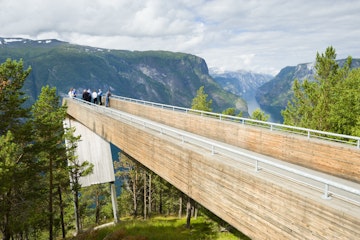 People taking in scenery of Aurlandsfjord at Stegastein viewpoint.