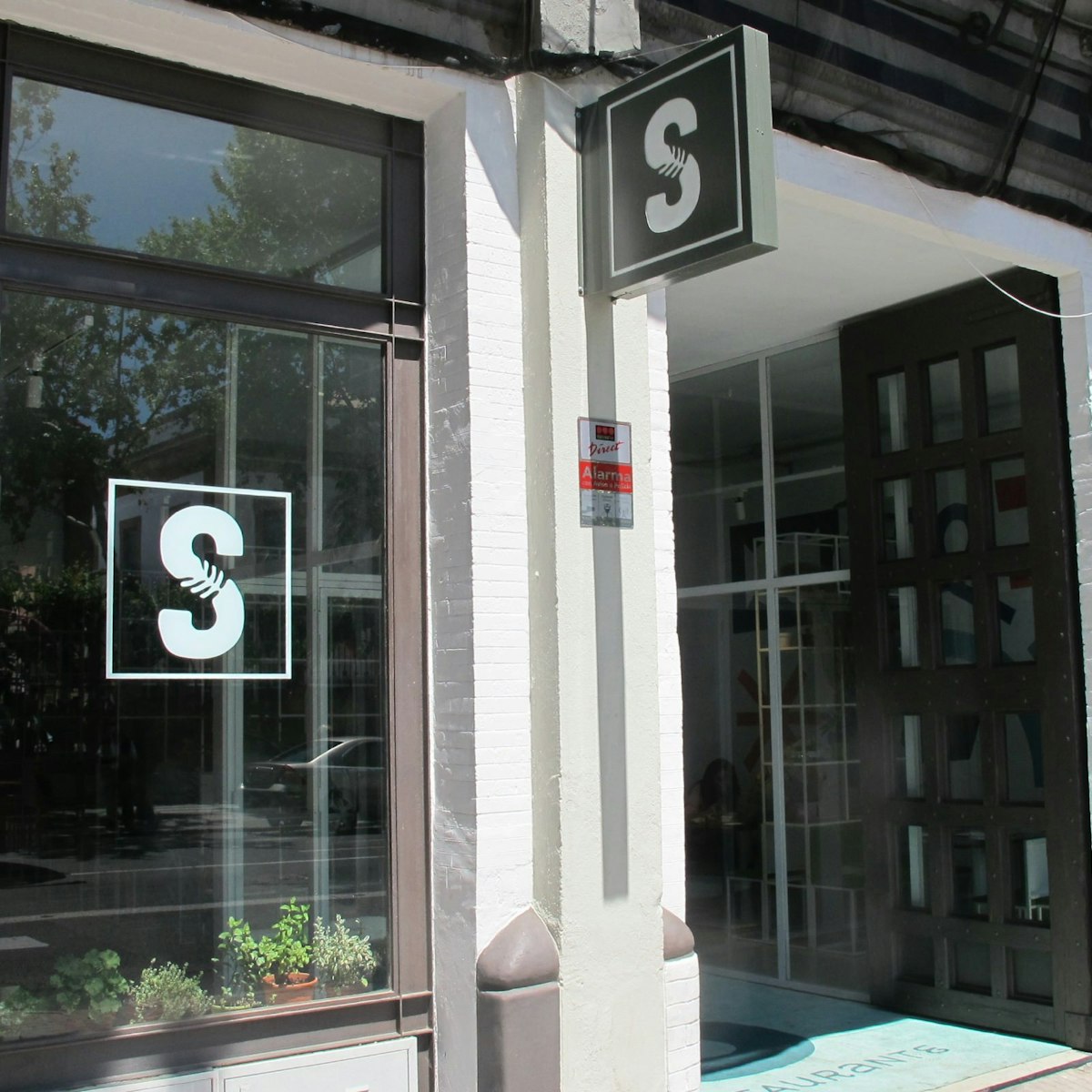 Facade of Salvaje restaurant with S sign in window.